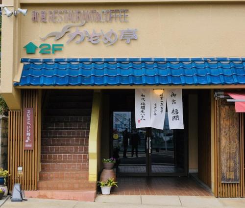 a store front with a blue awning on a building at Fukumakan in Matsue