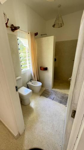 a bathroom with a white toilet and a window at Villa Rebecca 1 at Paparemo Village in Watamu