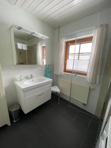 a white bathroom with a sink and a mirror at Kastanienhof in Kalleby