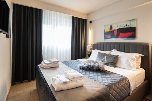 a hotel room with a bed with towels on it at ALEXANDRA Boutique Residence Seaside in Alexandroupoli