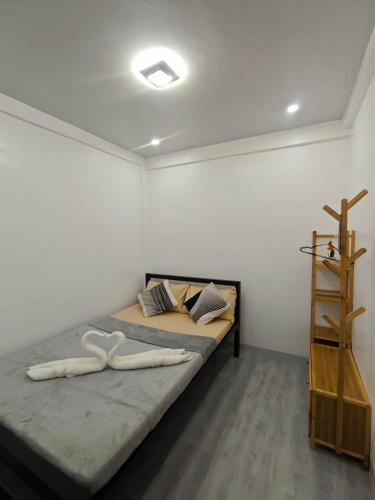 a bedroom with a bed with two white towels on it at Fab's Spot El Nido in El Nido