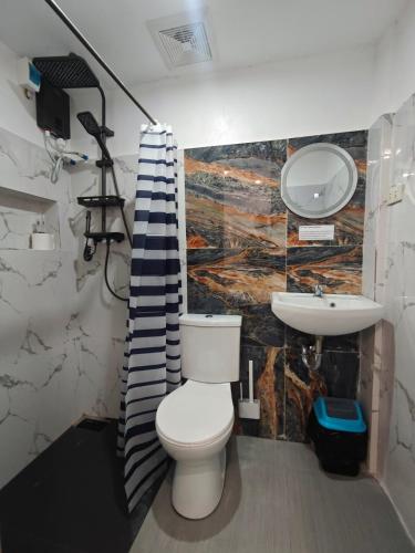 a bathroom with a toilet and a sink at Fab's Spot El Nido in El Nido