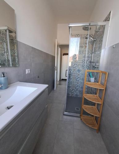 a bathroom with a shower and a white sink at Sweet home in Novara