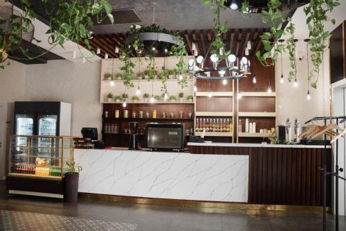 un bar in un ristorante con piante appese al soffitto di Cosmopolitan Hotel a Shymkent