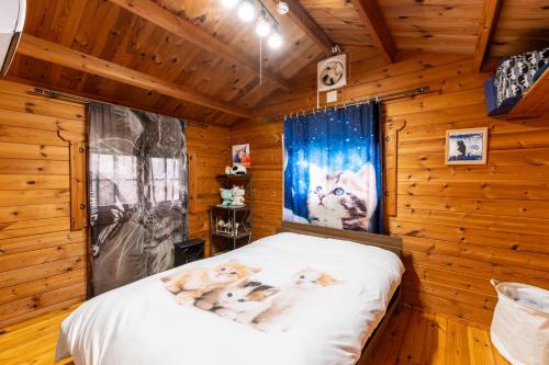 a room with a bed in a log cabin at Claude Monet ヴィンテージ那須ハイランドパーク車1分 一棟貸切 定員8名BBQ 無料Wifi in Nasu