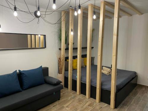 a living room with a bed with wooden posts at Loft2 Apartman X ker in Budapest