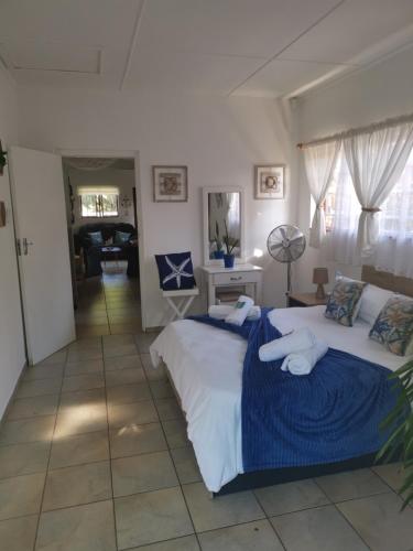 a bedroom with two beds with blue and white sheets at Michelle's Cottage by the Sea in Port Shepstone