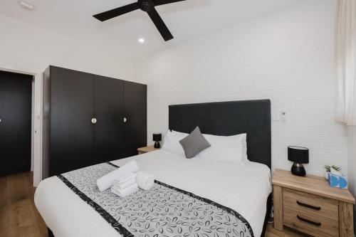a bedroom with a large bed with a black headboard at Palm Beach Villas by Rockingham Apartments in Rockingham