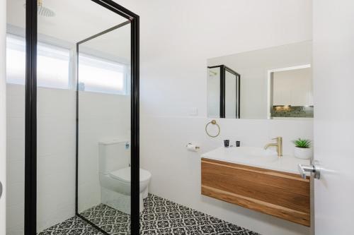 a bathroom with a tub and a sink and a toilet at Palm Beach Villas by Rockingham Apartments in Rockingham