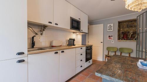 a kitchen with white cabinets and a wooden table at Artsy Sintra I by LovelyStay in Sintra