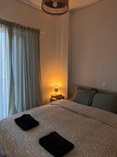 a bedroom with a bed with two black towels on it at Psani 50m2 apartment in Nafpaktos