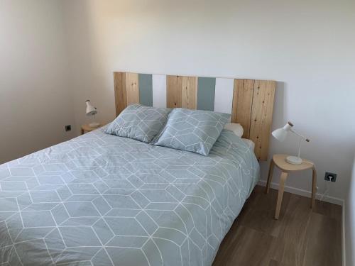 a bedroom with a large bed with a wooden headboard at Appartement Cozy in Le Monteil