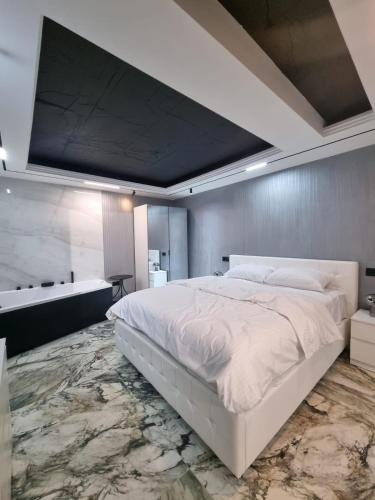 a bedroom with a large white bed and a bath tub at ApuLux Apartments in Alba Iulia