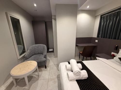 a hotel room with a bed and a table and chairs at Hotel Kurla Suites in Mumbai