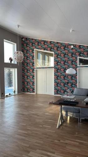 a living room with a table and a patterned wall at Lake View Villa in Falun