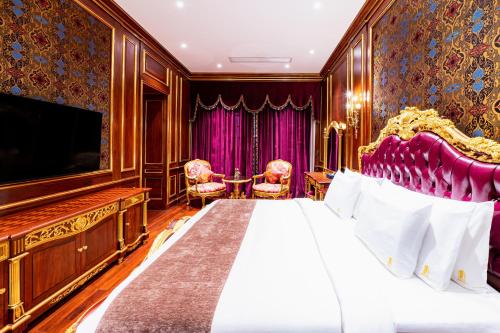 a bedroom with a king sized bed and a flat screen tv at V V Hotel Battambang in Battambang