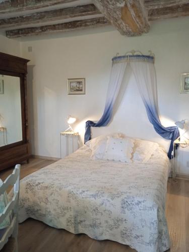 a bedroom with a bed with a blue canopy at La Closerie in Saint-Philbert-du-Peuple