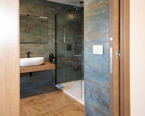 a bathroom with a sink and a glass shower at Guest house - L'amante e il marinaio in Fiumicino