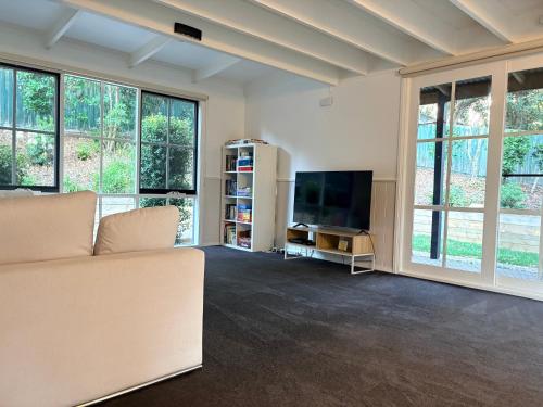 a living room with a couch and a flat screen tv at Bonza Family Retreat in Kalorama