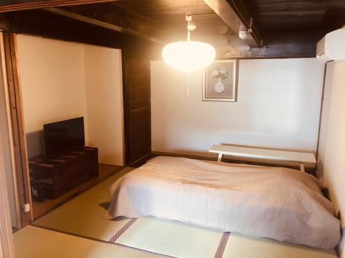 a bedroom with a bed and a television in it at Fukumakan in Matsue
