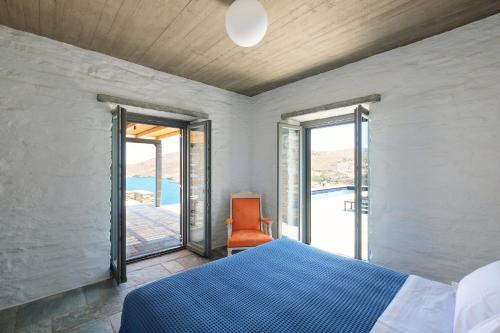a bedroom with a bed and a chair and a window at Kymo Kea in Otziás