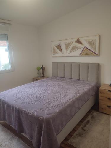 a bedroom with a bed with a purple bedspread at Bar ,2 sobni stan ,Namaste ! in Bar