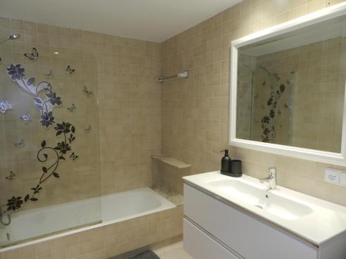 a bathroom with a sink and a tub and a sink and a mirror at Harmony Seafront 365 by Can Ventet in Port de Pollensa