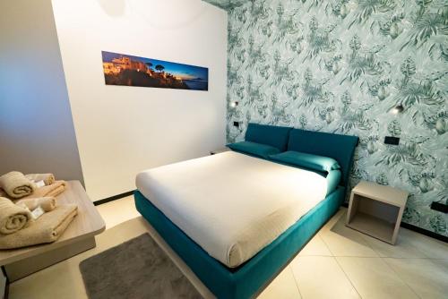 a bedroom with a bed and a blue and white wall at Cerasè Apartment in center-Sorrento Coast in Vico Equense