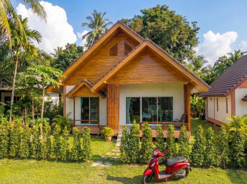 a house with a scooter parked in front of it at The Triangle Villas in Srithanu