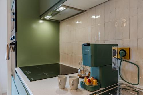 a kitchen counter with a coffee maker and two cups at Coquelicot in Caen