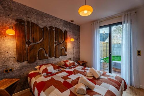 a bedroom with a large bed and a brick wall at Coquelicot in Caen