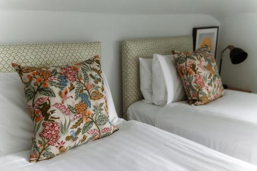 a bedroom with two beds and a pillow on it at Grey Walls in Penrith
