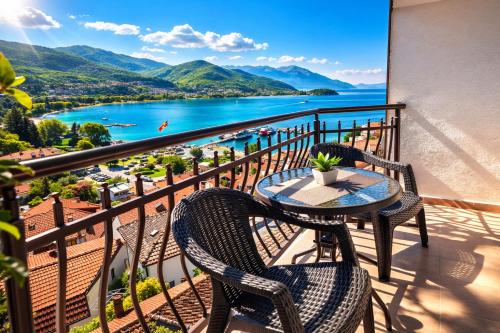a table and chairs on a balcony with a view of the water at Villa Mesokastro in Ohrid