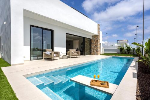 a swimming pool in the backyard of a villa at Villa Palmera in San Javier