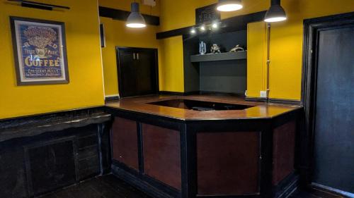 a kitchen with yellow walls and a wooden island at Bristol Hotel in Bristol