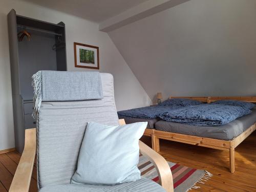 a bedroom with a bed and a chair and a couch at Ferienwohnung am Auenweg in Milstrich Oßling
