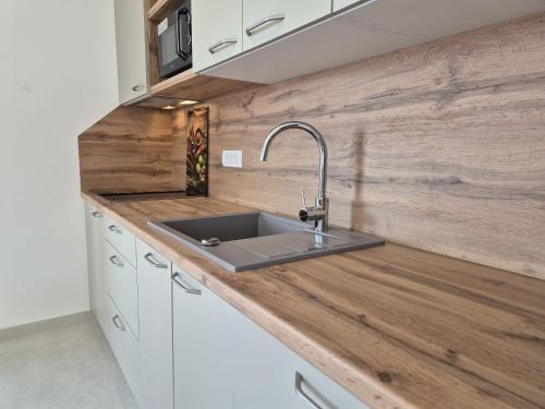 a kitchen with a sink and a wooden counter top at Natalija City 2 in Krk
