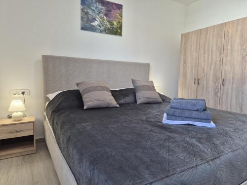 a bedroom with a large bed with gray sheets at Natalija City 2 in Krk