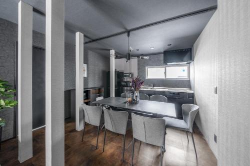 a kitchen and dining room with a table and chairs at Prunoia in Furano