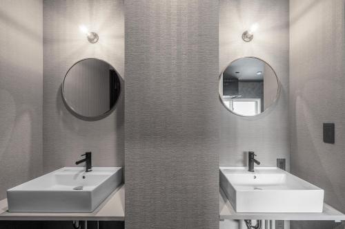 a bathroom with two sinks and two mirrors at Prunoia in Furano
