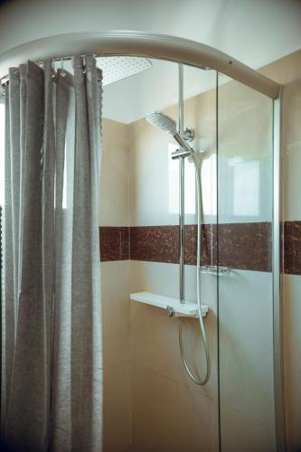a shower in a bathroom with a glass shower stall at Guest House Lumen in Lomé