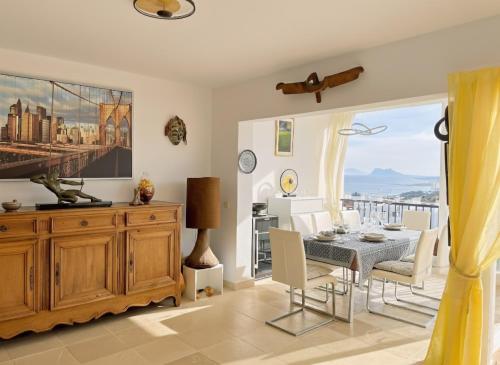 a dining room with a table and a view of the city at Blue Ark, villa vue mer avec piscine, idéale en famille face à Gibraltar in Manilva