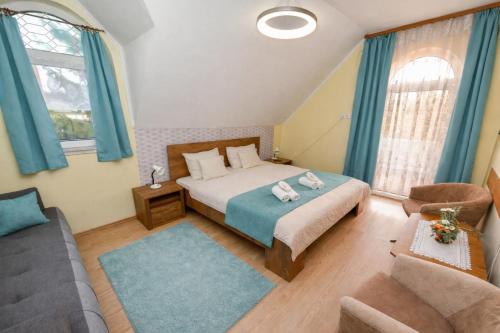 a bedroom with a bed and a couch at Lagúna Panzio Szántód in Szántód