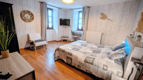 a bedroom with a bed and a table and a tv at Les Grands Champs in Attignat-Oncin