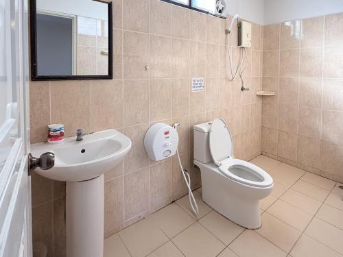a bathroom with a toilet and a sink at Baan Mak Mai Hotel in Si Sa Ket