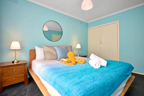 a bedroom with a large bed with a stuffed animal on it at Hampton Beach House in Melbourne
