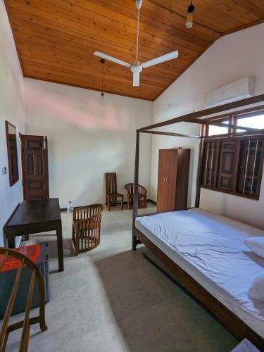 a bedroom with a bed and a wooden ceiling at Mango Tree Weligama in Weligama