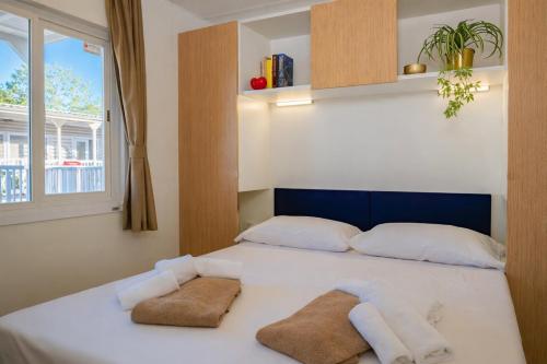 ein Schlafzimmer mit einem Bett, auf dem zwei Handtücher liegen in der Unterkunft Hotiday Lodge Grado in Grado