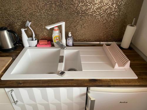 a white sink in a kitchen next to a counter at ARTep apartment in Pilsen