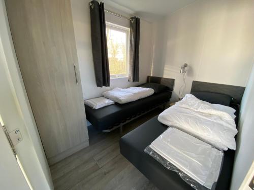 a small room with a bed and a couch at Chalet op Camping Mounewetter in Witmarsum